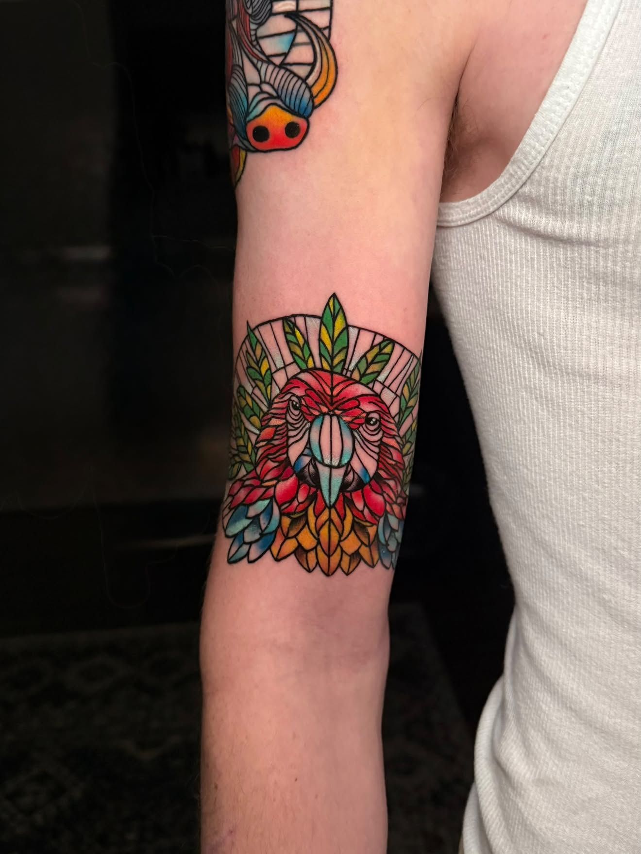 Forearm by Jenna, stained glass parrot in color